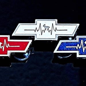 May include: Three silver bowtie emblems with a white silhouette of a goat and a red, white, or blue heartbeat graphic.