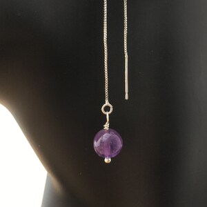 Könnte beinhalten: Ein Paar silberne Kettenohrringe mit einem violetten Amethyst-Edelstein, der an jeder Kette baumelt.