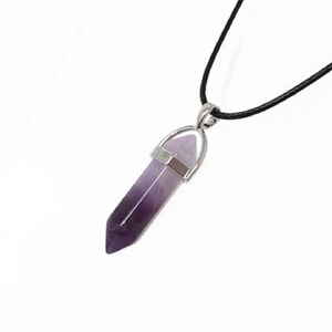 May include: A purple amethyst crystal point pendant on a black cord necklace. The pendant is silver-toned and has a pointed tip.