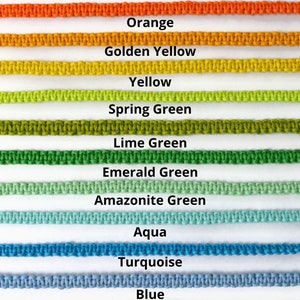 May include: A color chart featuring rows of macrame cord in various colors. The colors include red, orange, golden yellow, yellow, spring green, lime green, emerald green, amazonite green, aqua, turquoise, blue, and navy.