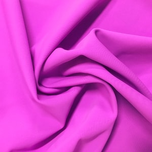 May include: A close-up of a vibrant, bright pink fabric with a soft, smooth texture. The fabric is folded and draped, creating a flowing, elegant look.