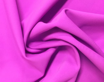 May include: A close-up of a vibrant, bright pink fabric with a soft, smooth texture. The fabric is folded and draped, creating a flowing, elegant look.