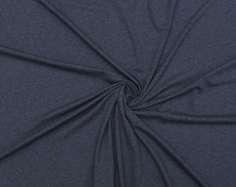 May include: Dark blue fabric with a soft texture, arranged in a spiral pattern. The fabric has a subtle heathered appearance, with variations in the blue color. The material is likely a knit or jersey fabric, suitable for apparel or home decor.