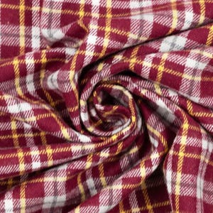 May include: Close-up of a fabric with a plaid pattern. The fabric features a repeating pattern of burgundy, white, and yellow lines. The fabric is folded and swirled, creating a textured appearance. The fabric is likely used for clothing or home decor.