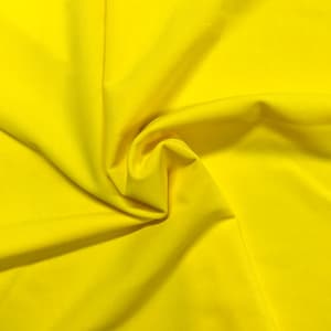 May include: A bright yellow fabric with a smooth texture. The fabric is folded and draped, creating soft folds and curves.