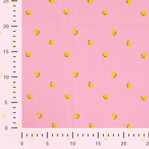 May include: Pink fabric with a repeating pattern of yellow lemons with green leaves. The lemons are evenly spaced across the fabric. The fabric is a solid pink color.