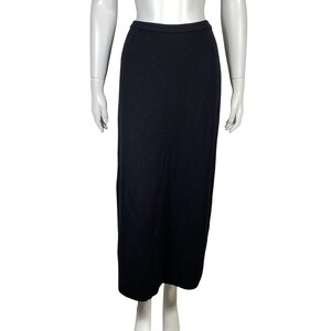 May include: A long, black skirt with a straight silhouette. The skirt appears to be made of a soft, knit fabric and has a simple, classic design. The skirt is displayed on a mannequin.
