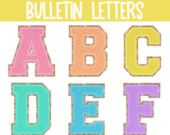 Op de afbeelding: Regenboog varsity bulletin letters in zes kleuren: roze, oranje, geel, turquoise, blauw en paars. De letters zijn A, B, C, D, E en F. De letters hebben een gouden glitterrand.