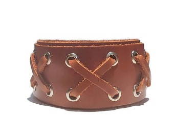 May include: A brown leather bracelet with a criss-cross design and silver eyelets.