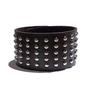 May include: Black leather bracelet with silver studs.