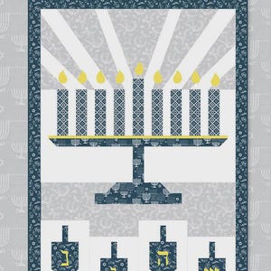 Puede incluir: Un patrón de quilt "Festival of Lights" de Tara Reed. El diseño presenta una menorá con velas encendidas, dreidels y un borde estampado. Tamaño final: 101,6 cm x 152,4 cm.