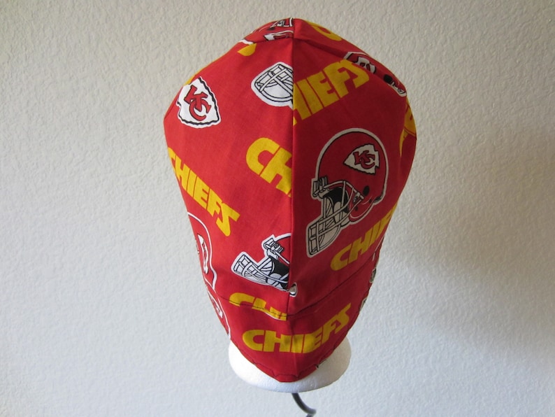 May include: Red and yellow fabric hat with the word "Chiefs" repeated and a football helmet logo.