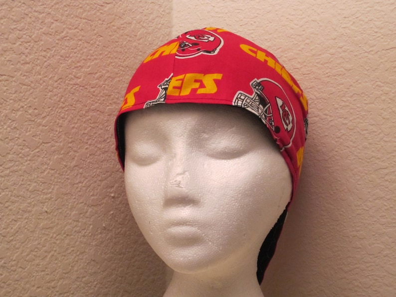 May include: Red and yellow fabric welding cap with the Kansas City Chiefs logo and the word "Chiefs" repeated on the fabric.