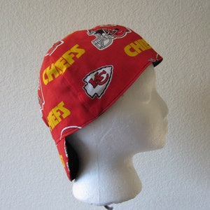 May include: Red and yellow fabric welding cap with the Kansas City Chiefs logo and the word "Chiefs" repeated on the cap.