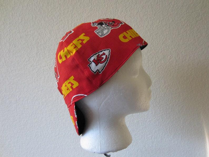 May include: Red and yellow fabric welding cap with the Kansas City Chiefs logo and the word "Chiefs" repeated on the cap.