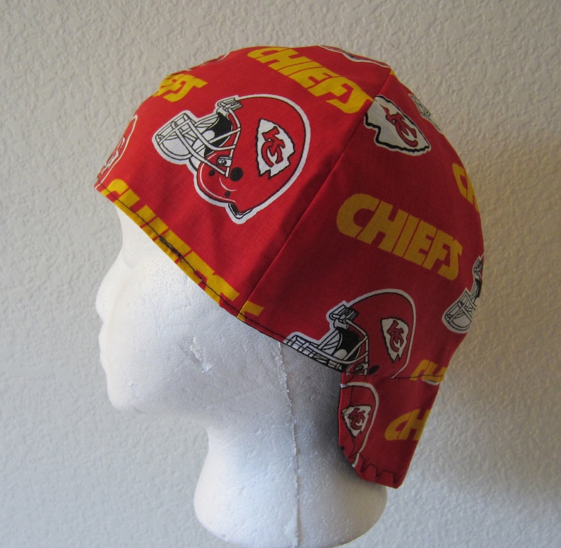 May include: Red and yellow welding cap with the Kansas City Chiefs logo and the word "Chiefs" repeated on the fabric.
