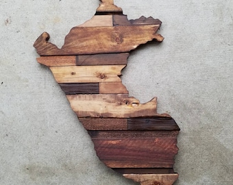 May include: A wooden wall art piece in the shape of Peru. The art is made from reclaimed wood planks in various shades of brown.