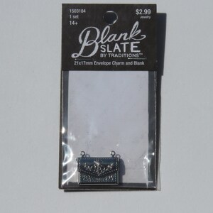 May include: A silver metal envelope charm with a floral design. The charm is 21mm x 17mm and is packaged on a card that reads "Blank Slate by Traditions 21x17mm Envelope Charm and Blank".