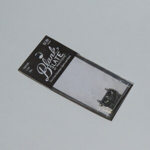 May include: A pack of 14 silver 21x17mm envelope charms and blanks from Blank Slate by Traditions. The pack is labelled with the price &pound;2.99.