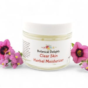 a jar of clear skin with flowers around it
