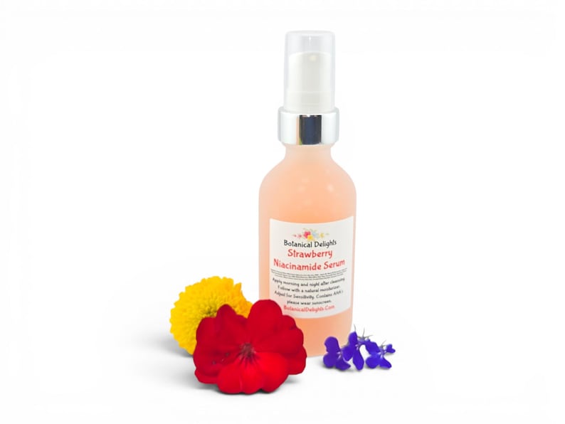 May include: A peach-colored serum bottle with a white label that reads "Botanical Delights Strawberry Niacinamide Serum." The bottle is next to a yellow flower, a red flower, and a cluster of small purple flowers. The bottle has a silver pump.