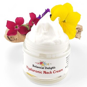 Op de afbeelding: Een witte pot Hyaluronzuur Halscr&egrave;me van Botanical Delights. De pot is open en de cr&egrave;me loopt eruit. De pot is omringd door kleurrijke bloemen.