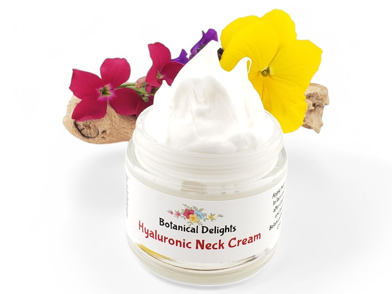 Op de afbeelding: Een witte pot Hyaluronzuur Halscr&egrave;me van Botanical Delights. De pot is open en de cr&egrave;me loopt eruit. De pot is omringd door kleurrijke bloemen.