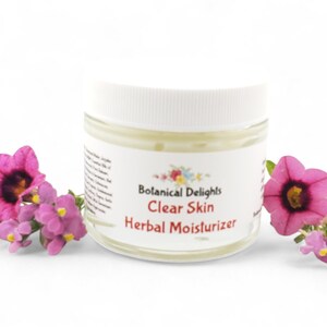 a jar of clear skin with flowers around it
