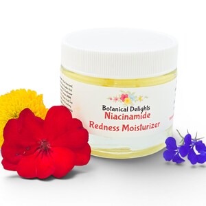 May include: A jar of Botanical Delights Niacinamide Redness Moisturizer with a white lid and a label with floral accents. The jar is surrounded by a red flower, a yellow flower, and a cluster of small blue flowers.