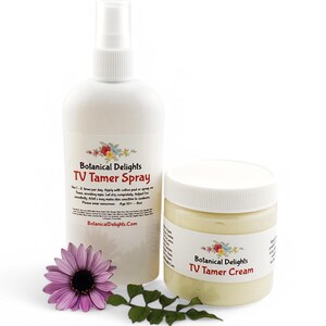 May include: A white bottle with a spray nozzle and a white jar with a cream inside. Both containers have a label that says "Botanical Delights TV Tamer Spray" and "Botanical Delights TV Tamer Cream".
