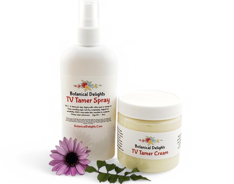 May include: A white bottle with a spray nozzle and a white jar with a cream inside. Both containers have a label that says "Botanical Delights TV Tamer Spray" and "Botanical Delights TV Tamer Cream".