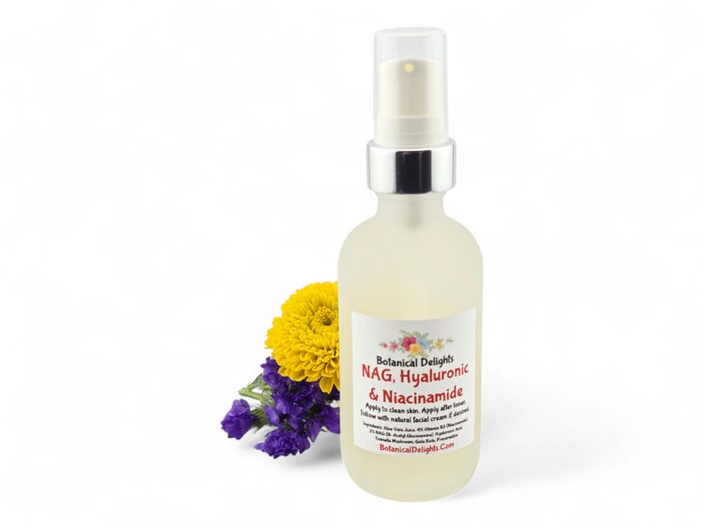 May include: A frosted glass bottle with a silver pump top, containing a skincare product. The label reads "NAG, Hyaluronic & Niacinamide." A yellow flower and purple flowers are next to the bottle. The background is white.