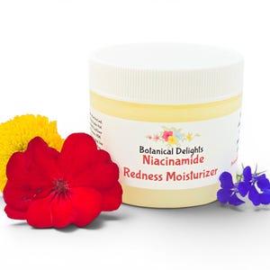 May include: A jar of Botanical Delights Niacinamide Redness Moisturizer with a white lid and a cream-colored body. The jar is surrounded by a yellow flower, a red flower, and a sprig of blue flowers. The product label is visible.