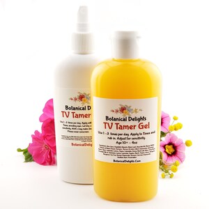 May include: Two bottles of skin care products, one white and one yellow, with labels that read "Botanical Delights TV Tamer" and "Botanical Delights TV Tamer Gel". The bottles are sitting on a white surface with pink and yellow flowers.