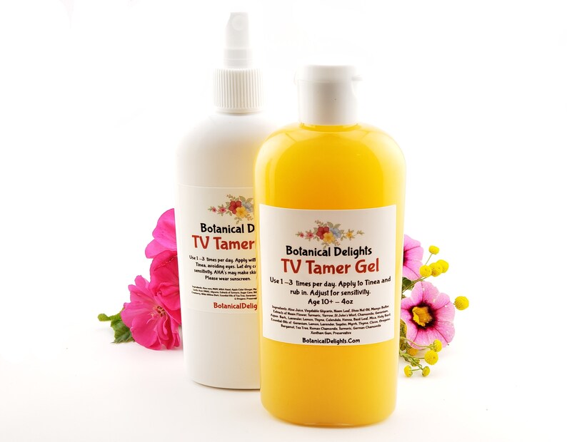 May include: Two bottles of skin care products, one white and one yellow, with labels that read "Botanical Delights TV Tamer" and "Botanical Delights TV Tamer Gel". The bottles are sitting on a white surface with pink and yellow flowers.