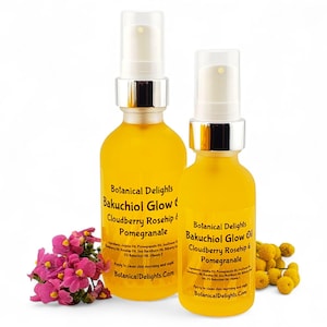 May include: Two yellow glass bottles of Botanical Delights Bakuchiol Glow Oil with Cloudberry Rosehip & Pomegranate. The bottles have silver spray tops and are surrounded by pink and yellow flowers. The text "Botanical Delights" is visible.