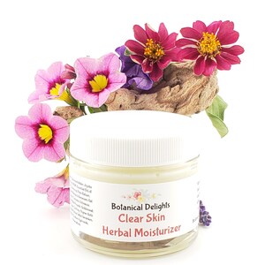 a jar of clear skin facial moister next to flowers