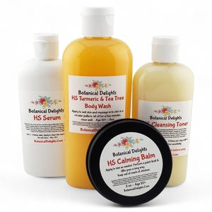 May include: Four skincare products in white bottles with black labels. The products are labeled "Botanical Delights" and include "HS Serum", "HS Turmeric & Tea Tree Body Wash", "HS Cleansing Toner", and "HS Calming Balm".