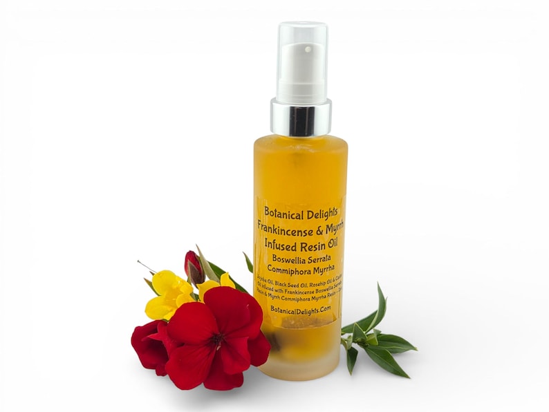 May include: A bottle of yellow resin oil with a silver pump, labelled "Botanical Delights Frankincense & Myrrh Infused Resin Oil." Red and yellow flowers and green leaves are arranged near the bottle. The bottle is made of clear glass.
