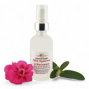 May include: A clear glass bottle with a silver pump top, labeled "Botanical Delights NAG, Hyaluronic & Niacinamide." A pink flower and green leaves are next to the bottle. The bottle contains a skincare product.