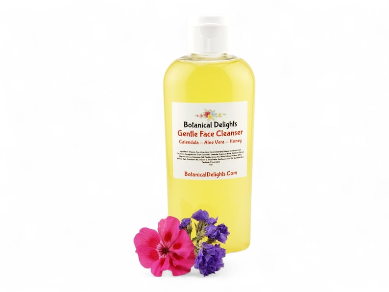 A bottle of "Balanced Delights" Gentle Face Cleanser, containing a yellow liquid, is surrounded by a few purple flowers.