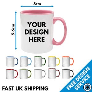 May include: A white ceramic mug with a pink interior and handle, featuring the black text YOUR DESIGN HERE. The mug measures 8 cm in width and 9.6 cm in height. Below, ten additional mugs are displayed in various rim and handle colour combinations.