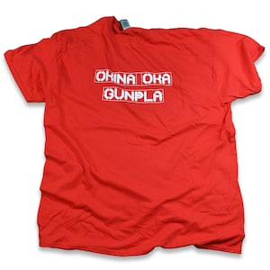 May include: Red t-shirt with white text that reads "OKINA OKA GUNPLA" in a pixelated font.