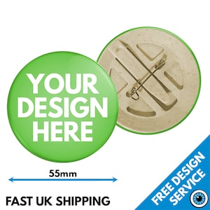 Puede incluir: Un botón verde con el texto "YOUR DESIGN HERE" en blanco. El botón tiene un diámetro de 55 mm y tiene un pasador de seguridad en la parte posterior.