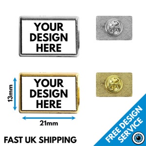 May include: Two rectangular metal pins with a gold and silver finish. The pins are 21mm wide and 13mm tall. The pins have a white background with black text that reads "YOUR DESIGN HERE".