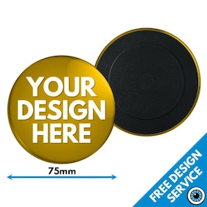 Puede incluir: Un imán redondo dorado con un centro negro. El imán tiene un diámetro de 75 mm y tiene el texto "YOUR DESIGN HERE" impreso en él.