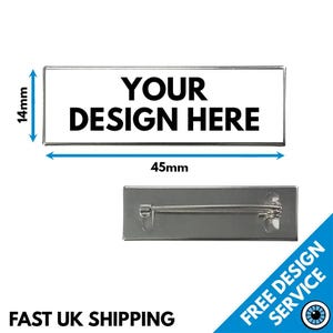 May include: A white rectangular pin back with a black border. The pin back is 1.77 inches wide and 0.55 inches tall. The text "YOUR DESIGN HERE" is printed in black on the pin back. A silver pin back is also shown.