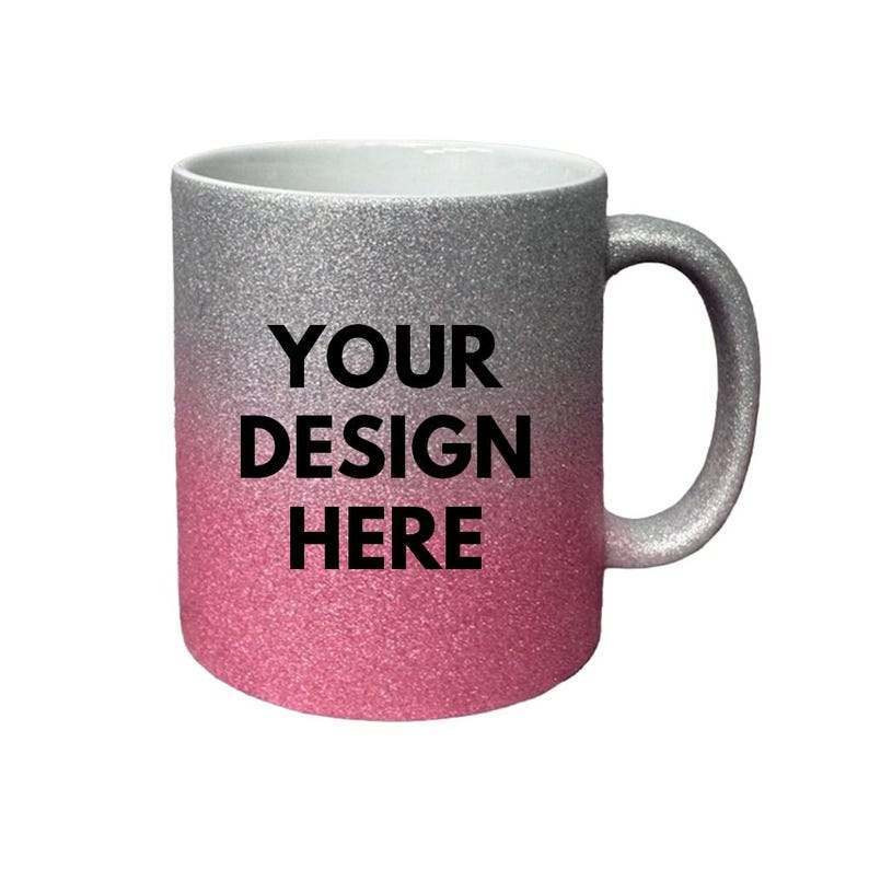 Puede incluir: Una taza de cer&aacute;mica con purpurina y un degradado de color plata a rosa. En la parte frontal de la taza aparece el texto negro "YOUR DESIGN HERE" en una fuente negrita sin remates. La taza incluye un asa con purpurina a juego.
