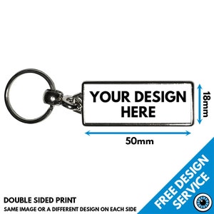 Puede incluir: Un llavero de metal plateado con una etiqueta rectangular que dice "YOUR DESIGN HERE". La etiqueta mide 50 mm de ancho y 18 mm de alto. El llavero es de doble cara, por lo que puedes agregar un diseño diferente a cada lado.