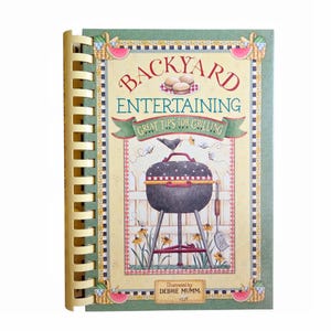Peut inclure: Un livre de cuisine à reliure spirale intitulé Backyard Entertaining: Great Tips for Grilling, illustré par Debbie Mumm. La couverture présente un barbecue noir, un oiseau et des fleurs jaunes devant une clôture blanche, encadrés par une bordure verte.